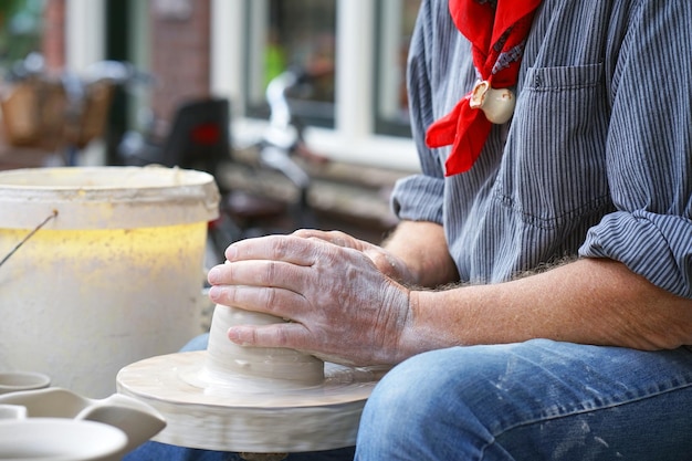 A man makes a pitcher of clay