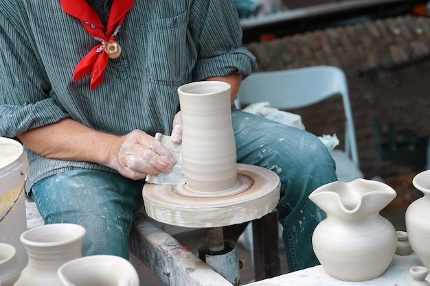 A man makes a pitcher of clay