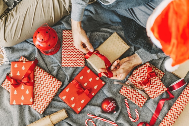 Man making bow from ribbon on gift