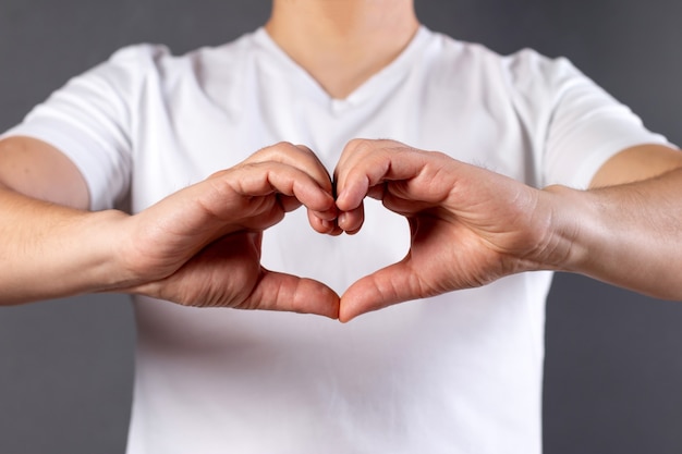 Man making a heart shape with his hands isolated