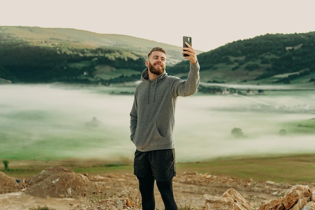 Man making selfie on top of mountain