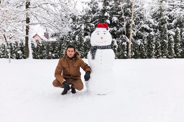 man making a snowman in his yard.