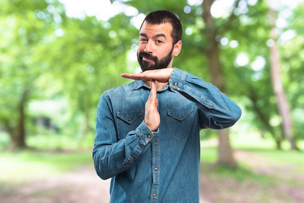 Man making time out gesture on unfocused background