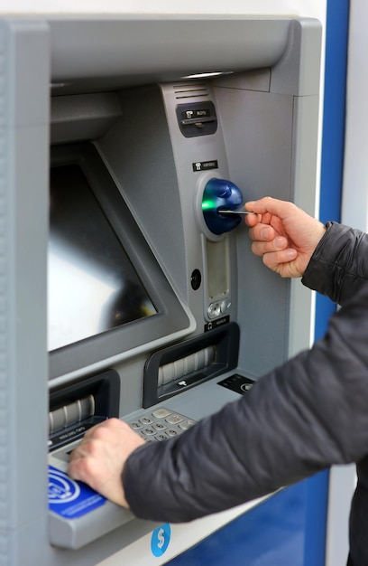 A man making a transaction with a credit card at an ATM Automated Teller Machine