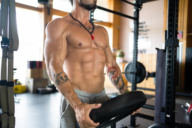 Man making weights with discs in a gym