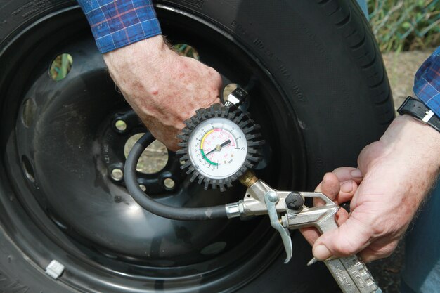 man measuring tire pressure