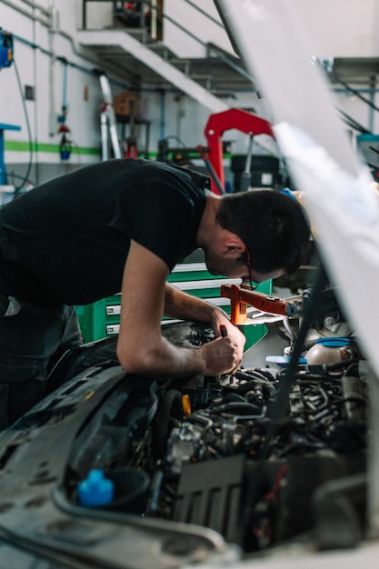 Man mechanic working on car at repair shop