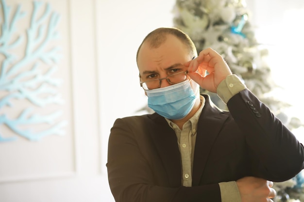 A man in a medical mask holds a pack of one hundred dollar bills in his hands The economic growth