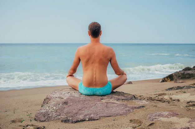 Man meditates by the water