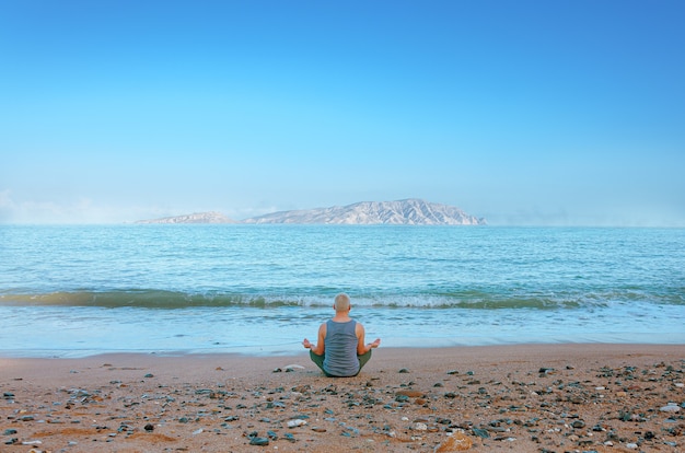 Man meditating on the seashore