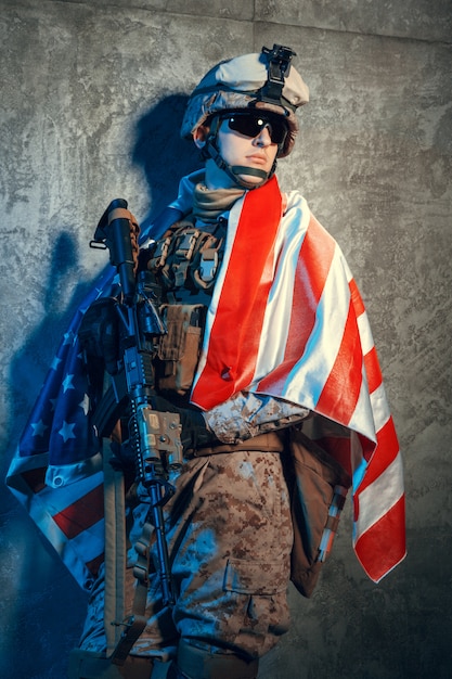 Man military outfit a mercenary soldier in modern times with US flag in studio