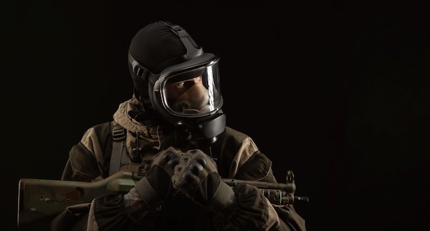 A man in a military uniform and a gas mask holds a weapon with an angry expression of emotion