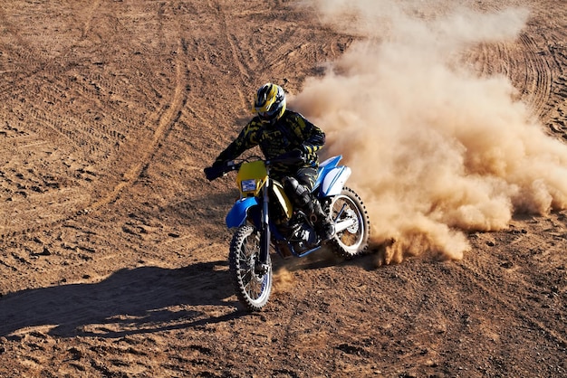 Man motorcycle and bike dust cloud as professional rider in action danger competition fearless or race Male person transportation or fast speed dirt adventure or rally challenge gear or driving