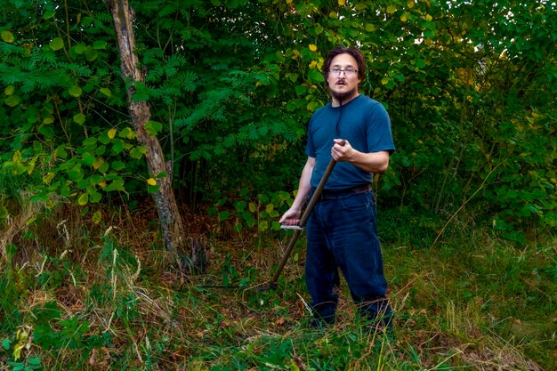 A man mows the grass with a authentic hand scythe