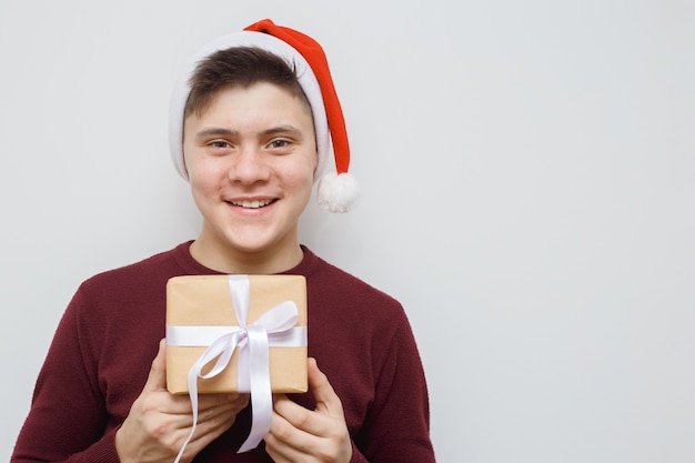 Man offering or showing a gift for someone. Happy young hipster with a gift in hands. 