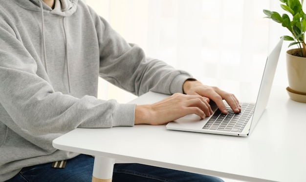 Man in office behind table working on laptop