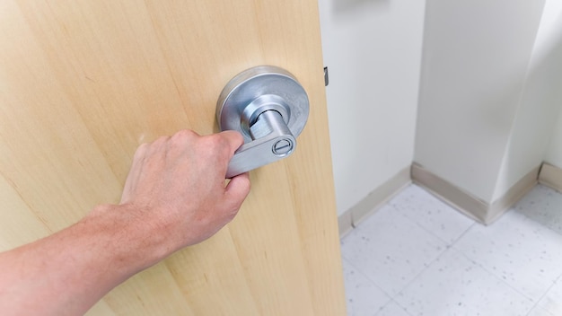 A man opening a door with a lock that says " no. "