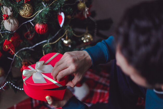 Man opening red heart present box with his hands