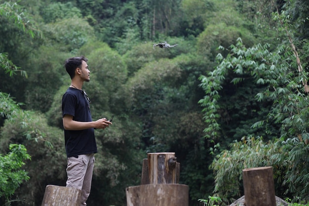 A man operating the drone by remote control in the greeny park Drone pilot