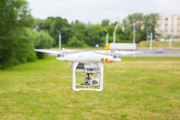 Man Operating Drone Flying or Hovering by Remote Control in Nature