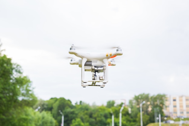 Man Operating Drone Flying or Hovering by Remote Control in Nature