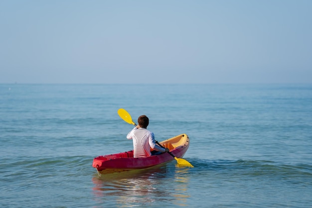 Man paddling a kayak boat in the sea