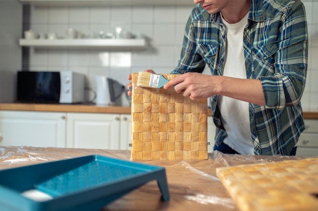 Man painting the box side pieces on the kitchen table