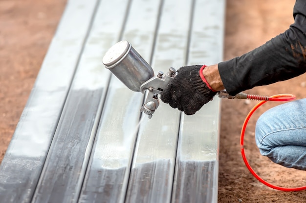 Man painting steel with airbrush