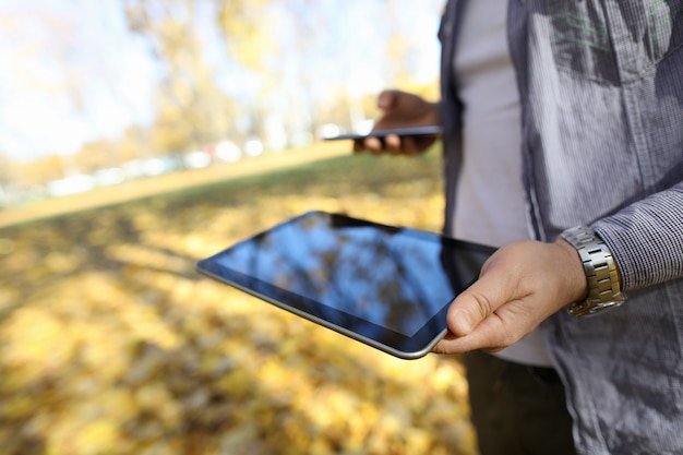 Man in pakr hold digital tablet pc with blank screen