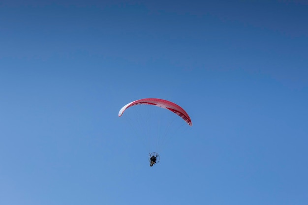 Man paragliding in clear blue skies