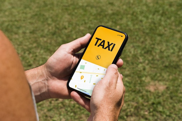 Man in the park holding a smartphone with Taxi Service app on the screen. Mobility service provider worldwide.