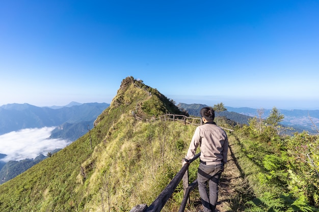 Man at the of a path on the top of a mountain