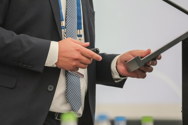 Man performs on conference from rostrum for audience, telephoto shot