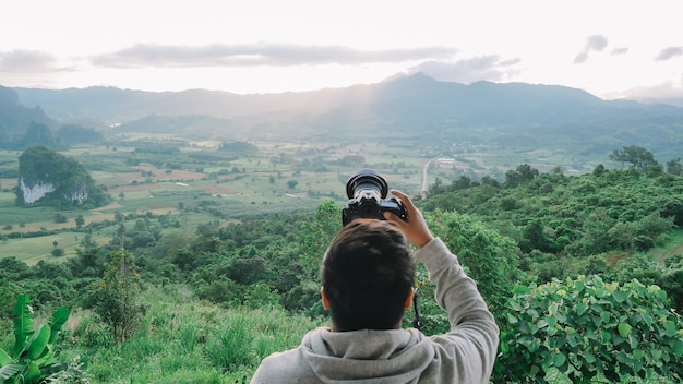 Man photographers and camera are shooting sunrise on the mountain.