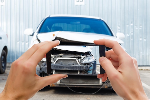 Man photographing his vehicle with damages for accident insurance with smart phone.