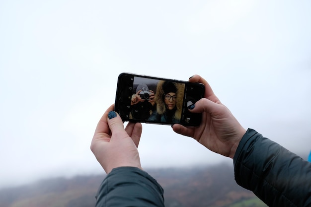 Photo man photographing with mobile phone against sky