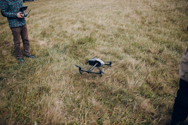 Man pilot controlling quadcopter drone with remote controller pad.