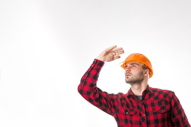 A man in a plaid shirt and a construction helmet isolated