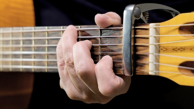 A man playing on acoustic guitar closeup and front view