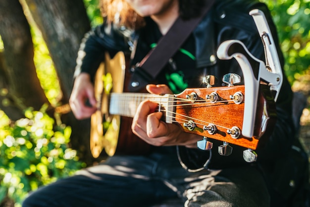 Man playing acoustic guitar and playing chords closeup