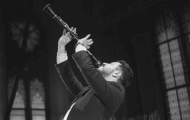 Man playing clarinet while standing at studio