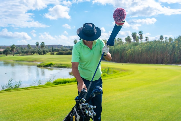 Man playing golf picking up the club after the throw in the club bag