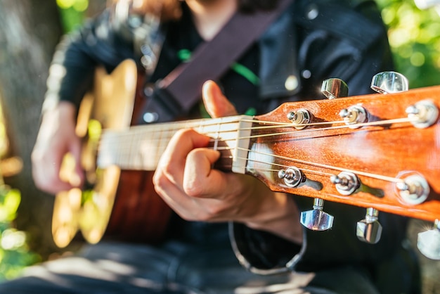 Man playing guitar in nature on a sunny day