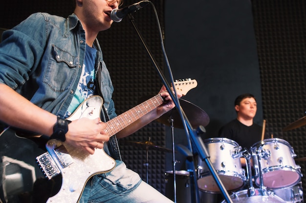 Man playing guitar and singing with drummer