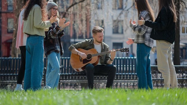 Photo a man playing guitar and a woman playing guitar in the park