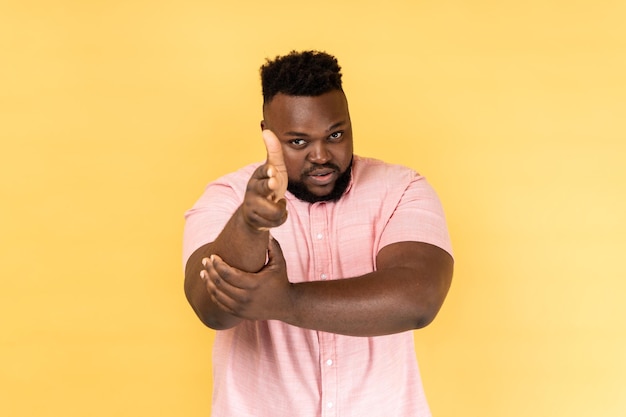 Man pointing finger guns to camera looking aggressive threatening to shoot hands imitating weapon