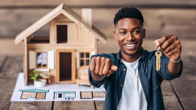 a man pointing at a model house with a picture of a house on the wall