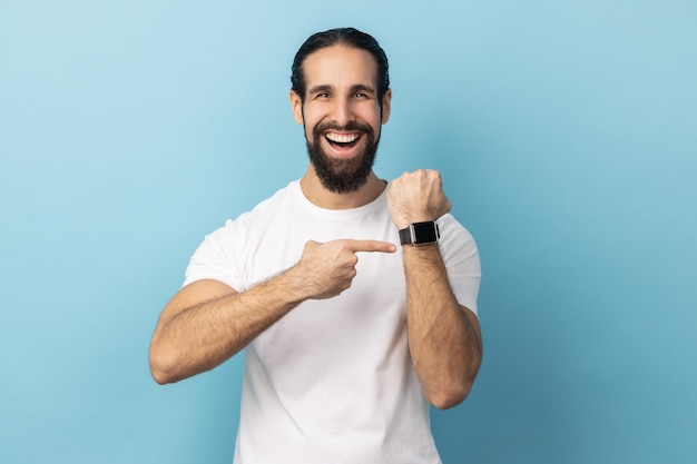 Man pointing wrist watch and expressing optimism about time not busy