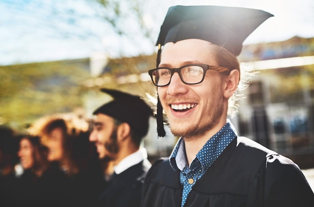 Man portrait and smile for university graduation with glasses happiness for degree or diploma event People graduate class or education achievement at college campus pride for goal with knowledge