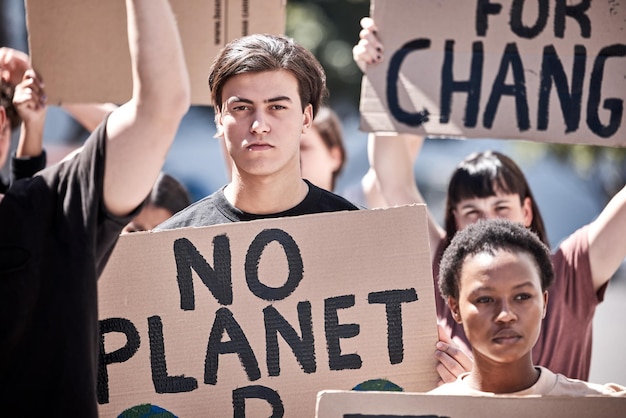 Photo man posters and protest in outdoor portrait saving planet and rally for climate change in society male person public movement and community for voice march and riot global problem or cardboard